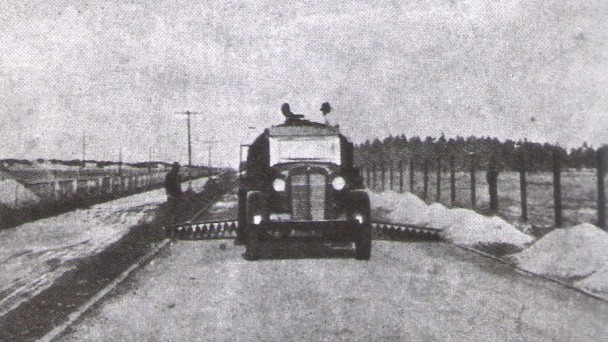 A foto antiga e em preto e branco, da década de 1940, mostra uma máquina atuando nas obras de pavimentação da rodovia Rio Grande - Cassino