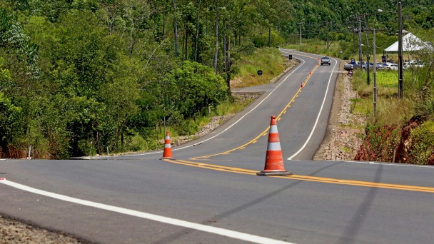 A foto mostra a rodovia TQ-150, em Taquari, recentemente pavimentada. Há cones de sinalização na faixa central da pista.