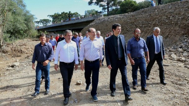 A foto mostra o governador José Ivo Sartori e demais lideranças políticas andando ao lado das obras da nova ponte sobre o Arroio Taipa, entre os municípios de Soledade e Arvorezinha.