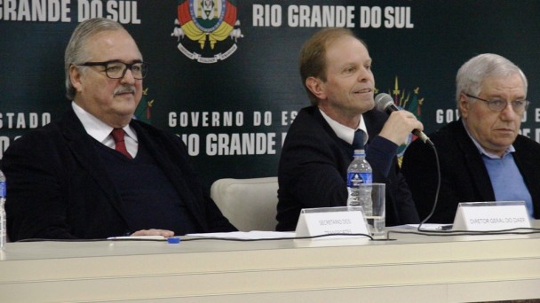 A foto mostra o diretor-geral do Daer, Ricardo Nuñez, sentado em uma bancada e falando ao microfone. Ao lado esquerdo dele, o diretor de Gestão e Projetos Jayme Tonon. À direita, o secretário dos Transportes Pedro Westphalen.