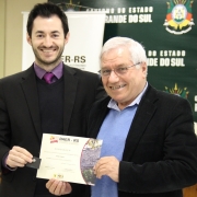 A foto mostra o diretor de Gestão e Projetos do Daer, Jayme Tonon, recebendo o diploma de 46 anos de serviços prestados ao Daer. Quem entrega é o diretor de Infraestrutura Rodoviária, Luciano Faustino.
