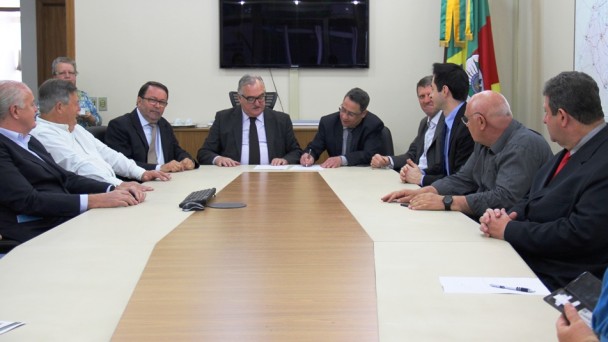 Na foto, o diretor-geral do Daer, Rogério Uberti, assina a ordem de reinício da obra da ERS-165, ao lado do secretário Pedro Westphalen. Na mesma mesa, diretores do Daer, empresários e autoridades políticas participam do ato.