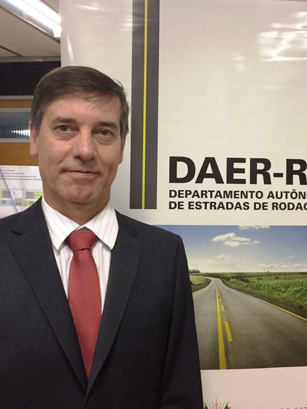 Foto do Diretor de Gestão e Projetos, engenheiro civil Sívori Sarti da Silva. Ao fundo um banner institucional do Daer.
