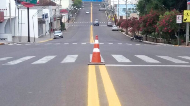 A foto destaca o eixo central e das faixas de segurança, recém pintados na ERS-409, em Vera Cruz. Há um cone de sinalização bem no meio da pista. Ao fundo, prédios do Centro da cidade.