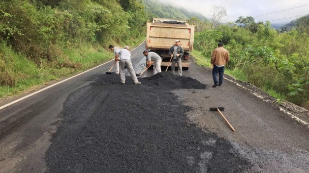 Na foto, funcionários do Daer cobrem a rachadura no quilômetro 12,2 da ERS-431, em Monte Belo do Sul, na Serra. Há material asfáltico depositado no local e um caminhão é usado para os serviços.