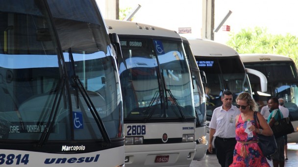 A foto mostra quatro ônibus estacionados na rodoviária de Porto Alegre.