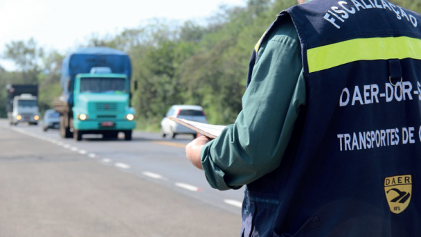 Imagem png de fiscal de costas avisando um caminhão em uma rodovia do Daer