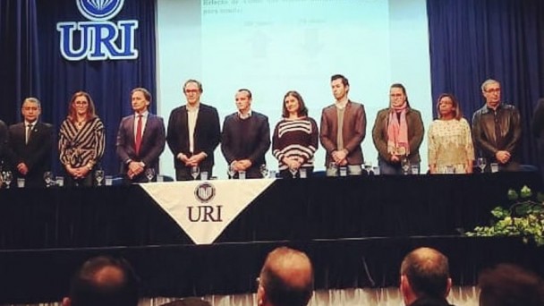 A foto mostrar os técnicos do DAER em pé enfileirados, lado a lado. Ao fundo, o logotipo da universidade URI. 