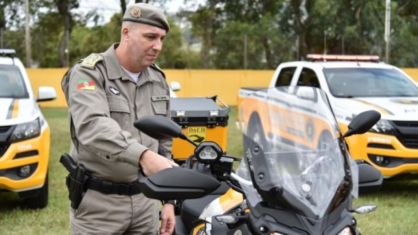 A foto mostra um soldado do CRBM ao lado de uma moto recém adquirida. Ao fundo, carros novos do CRBM .