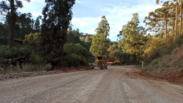 A foto mostra a rodovia ERS-020. Nela, transita uma máquina que está preparando a estrada para ser pavimentada.