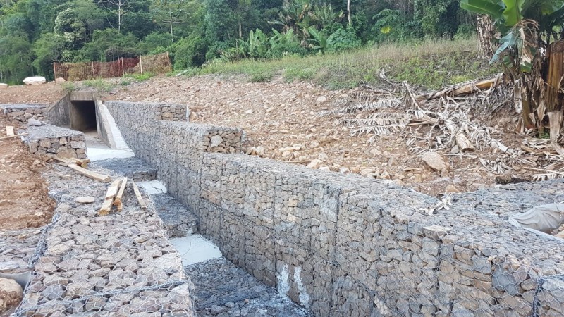 Na imagem pode ser ver uma estrutura subterrânea feita com pedras e aço. Na parte superior, ou seja, em cima da terra, é possível notar a grande presença de vegetação no local.