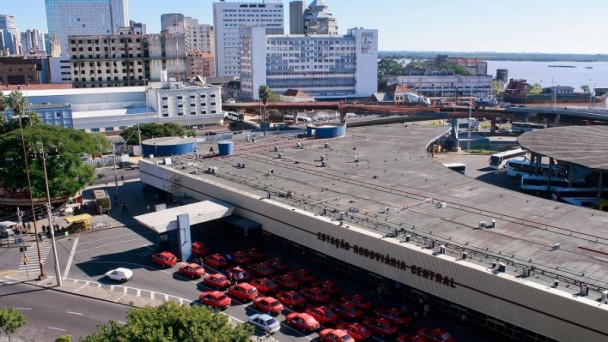 Foto aérea que mostra a fachada Estação Rodoviária de Porto Alegre, contendo grande quantidade de Taxis na cor laranja.