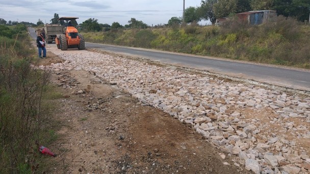 A imagem mostra máquinas compactando pedras, para substituição do asfalto danificado