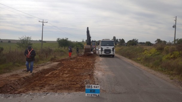 A imagem mostra homens e máquinas trabalhando na retirada do asfalto