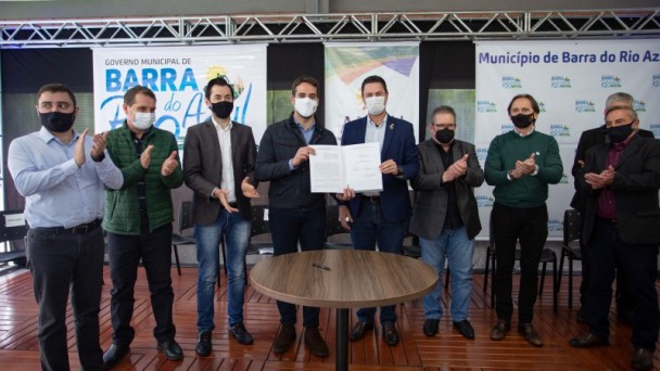 A imagem mostra Governador Leite e vice Ranolfo com prefeito de Barra do Rio Azul, Marcelo Arruda, e integrantes da comitiva posando para foto após a assinatura dos documentos