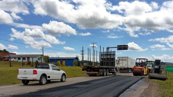 A imagem mostra máquinas trabalhando no novo asfalto em um dos lados da pista.