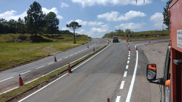 Imagem mostra rodovia sinalizada por cones durante pintura das sinalizações