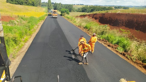 Imagem mostra homens aplicando o novo asfalto