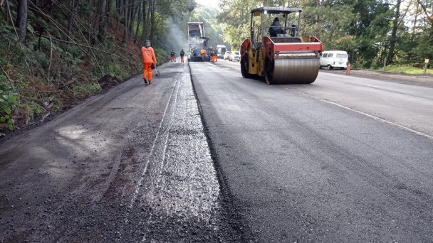 Imagem mostra máquinas durante a aplicação e compactação do novo asfalto