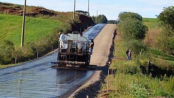 Imagem mostra máquina realizando a aplicação do asfalto