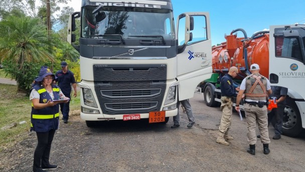 Fiscais em frente aos caminhões realizando abordagens