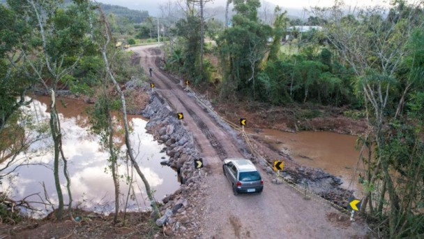 A foto mostra uma imagem aérea de um carro transitando na passagem,