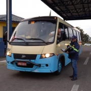 Imagem de uma van de transporte de turismo sendo fiscalizada por um servidor do Daer.