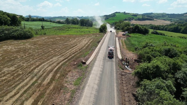A foto aérea mostra um trecho da ERS-325, em Novo Tiradentes, com pavimentação avançada e máquinas na pista.