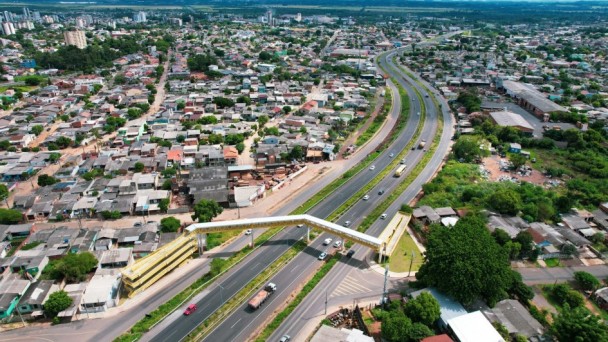 Imagem área da ERS-118 onde aparece a rodovia, passarela de pedestres, casas e prédios do entorno.